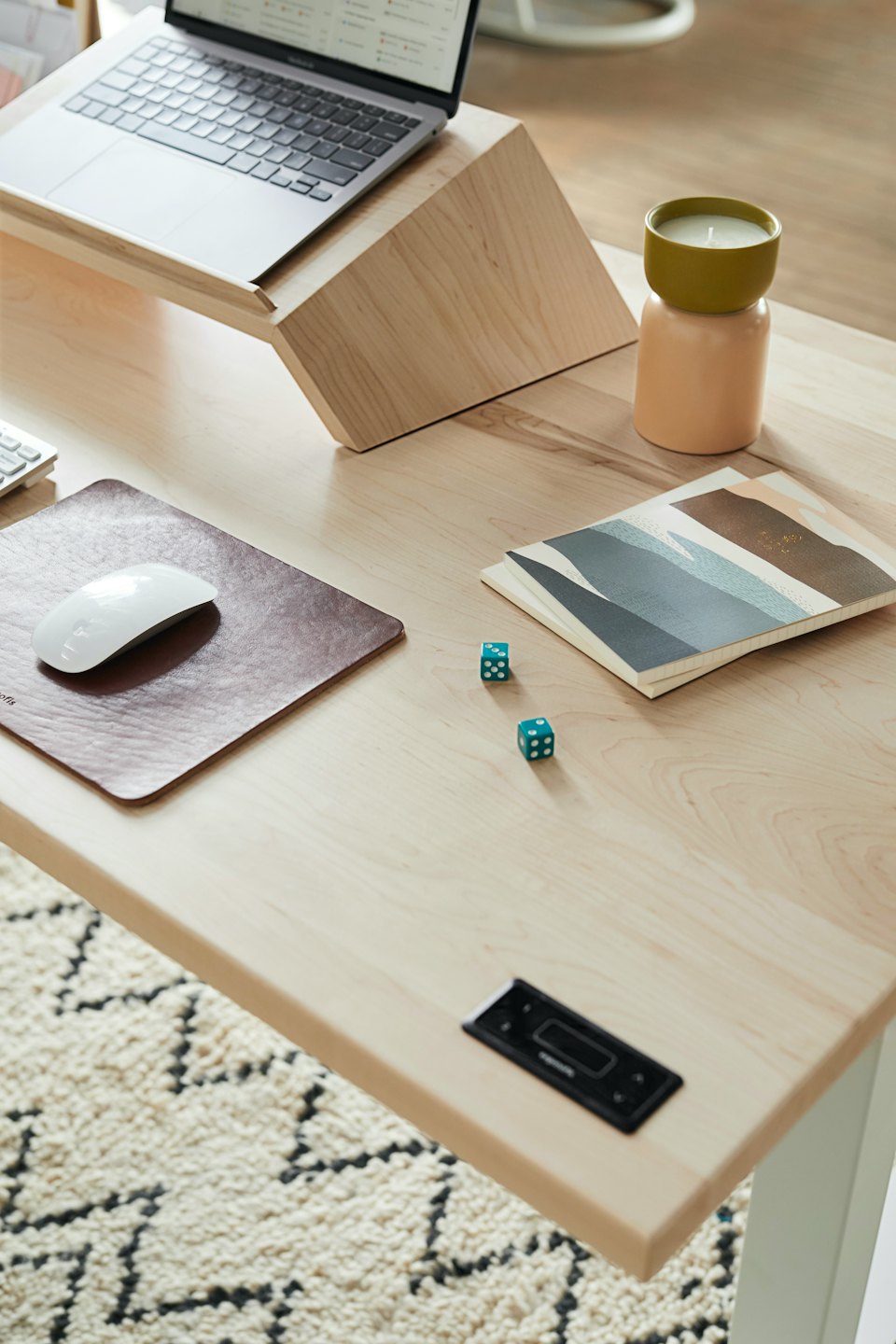 Organisierter Schreibtisch im Homeoffice mit Laptop, Maus und Würfeln.